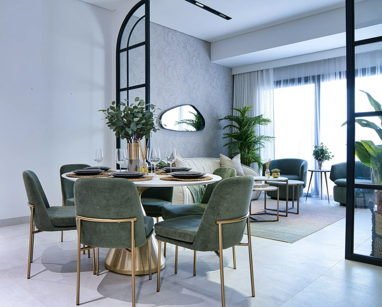 Furnished apartment living and dining area with large windows