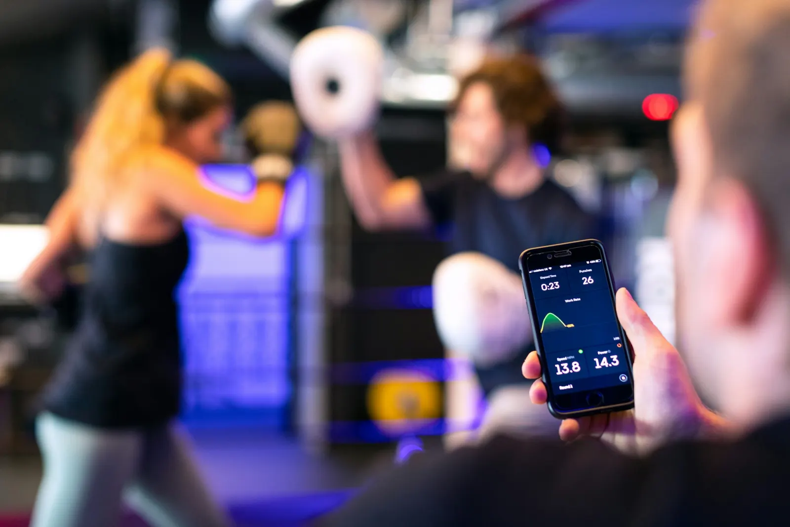 Phone showing a workout tracking screen in a gym