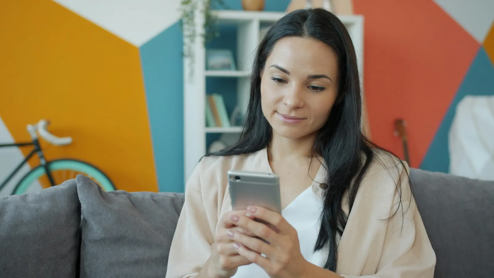 Woman scrolling a fitness app on her phone at home
